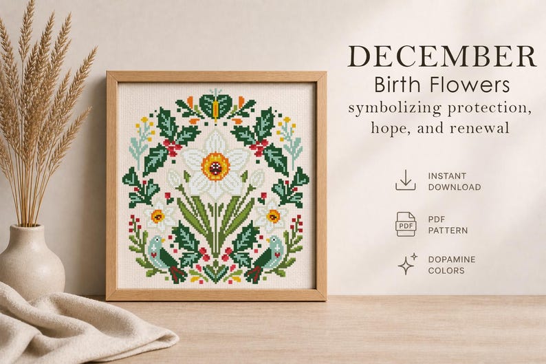 May include: A framed cross-stitch pattern featuring a white daffodil with a yellow center, surrounded by green leaves, red berries, and small birds. The text reads "DECEMBER Birth Flowers" and "symbolizing protection, hope, and renewal."
