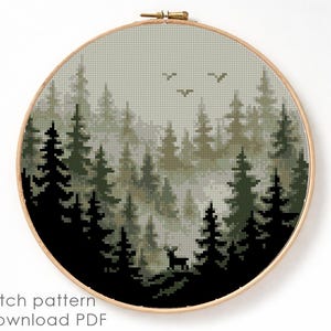 May include: A cross-stitch pattern of a forest scene, featuring tall evergreen trees in shades of green and black, with a deer silhouette. The design is set within a round wooden embroidery hoop. The text "Cross stitch pattern Instant download PDF" is at the bottom.