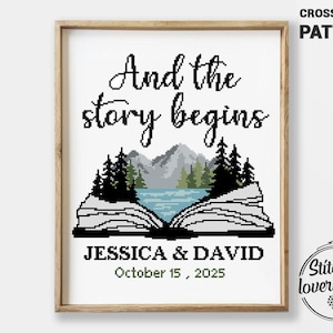 May include: A framed cross-stitch pattern with the text "And the story begins." The design features a mountain and lake scene within an open book. The names "JESSICA & DAVID" and the date "October 15, 2025" are below the image.
