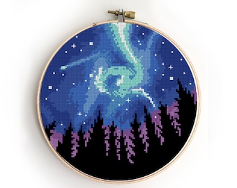 Puede incluir: Patrón de punto de cruz de un cielo nocturno con una aurora boreal verde y una silueta de un bosque en primer plano.