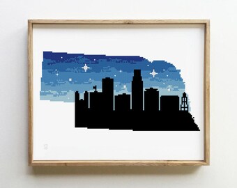May include: A cross-stitch pattern of the Omaha, Nebraska skyline with a blue and white starry night sky background.