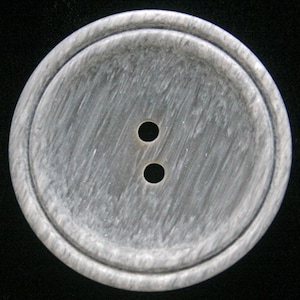 May include: A two-hole gray button with a raised rim. The button has a wood-like texture.