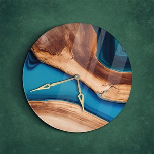 Puede incluir: Un reloj redondo con un diseño de resina azul y marrón. La esfera del reloj tiene agujas doradas y un patrón de veta de madera.