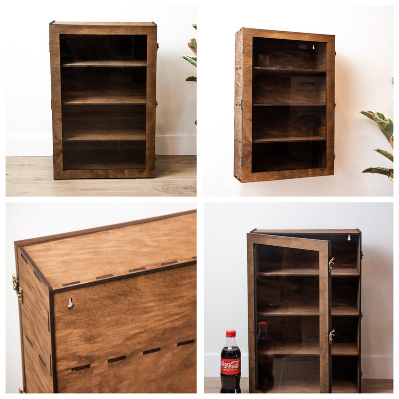 May include: A wooden wall-mounted display cabinet with three shelves and a glass door. The cabinet is made of dark wood and has a rustic look. The cabinet is empty.