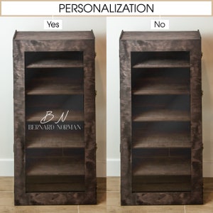 May include: A dark brown wooden cabinet with glass doors and four shelves. The cabinet has a personalized inscription that reads "BN BERNARD NORMAN".