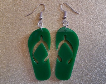 May include: A pair of green flip-flop earrings with silver hooks. The flip-flops are cut out and have a simple design.