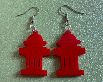 May include: A pair of red fire hydrant earrings with silver hooks. The earrings are made of acrylic and are about 2 inches tall.
