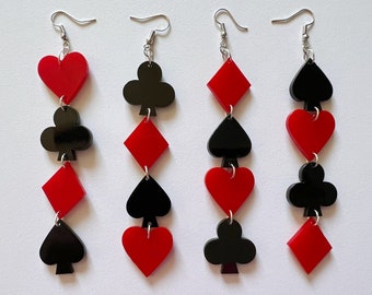 May include: A pair of dangle earrings featuring alternating black and red card suit shapes. The suits are hearts, diamonds, and clubs.