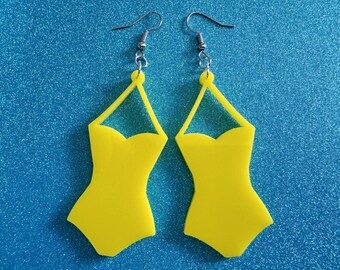 May include: A pair of yellow swimsuit-shaped earrings with silver hooks.