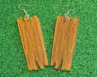 May include: A pair of wooden earrings with a unique, jagged design. The earrings are a rich brown color and have a natural wood grain pattern.