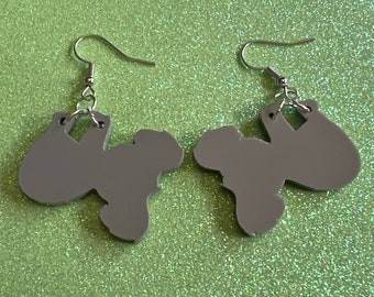 May include: A pair of gray dangle earrings with a unique shape. The earrings are made of a lightweight material and have a silver hook.