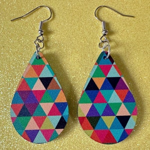 May include: A pair of teardrop-shaped earrings with a geometric pattern of colorful triangles. The earrings are made of wood and have silver hooks.