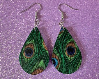 May include: A pair of teardrop-shaped earrings featuring a peacock feather design. The earrings have a green, blue, and brown pattern, with silver-colored hooks. The earrings are lightweight and suitable for everyday wear.