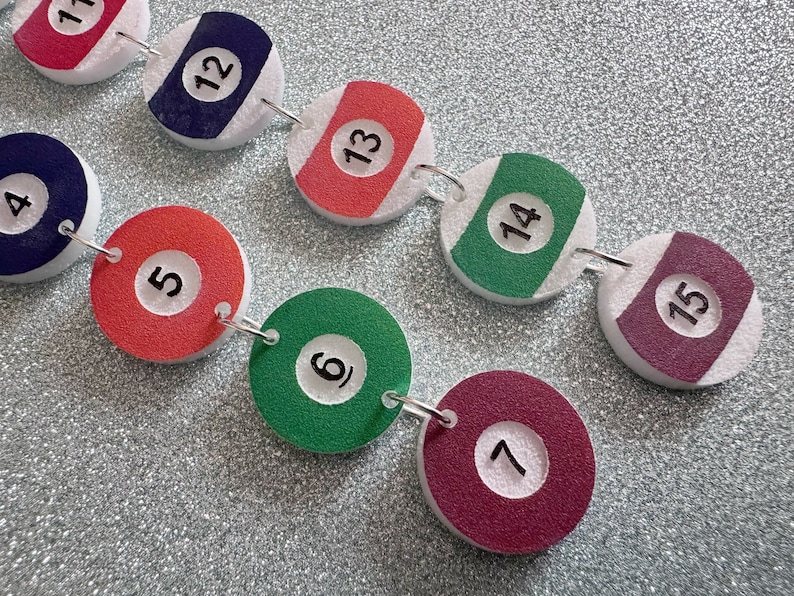 May include: A chain of 10 round, white, foam-backed, felt circles with black numbers 1 through 15. Each circle has a different color: red, blue, red, green, red, green, maroon, maroon, green, maroon.
