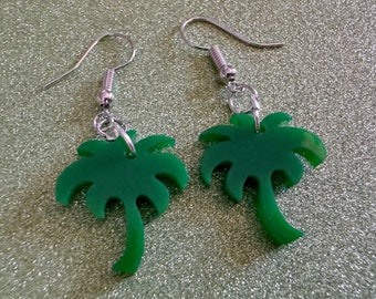 May include: A pair of silver earrings with green palm tree charms. The palm trees are made of a shiny, opaque material.