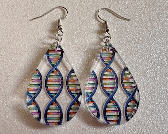 May include: A pair of teardrop-shaped earrings with a silver hook and a clear background. The earrings feature a colorful DNA double helix pattern.