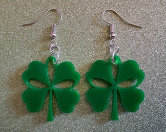 May include: A pair of green four-leaf clover earrings with silver hooks.