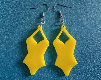 May include: A pair of yellow swimsuit-shaped earrings with silver hooks.
