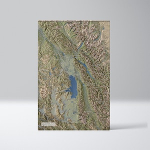 May include: A topographic map of the Flathead Valley in Montana, showing the mountains, rivers, and lakes in the area. The map is in shades of green, brown, and blue.