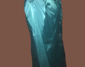 May include: A teal blue blazer with a long, pointed collar and a single button closure. The blazer has a smooth, silky texture.