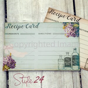 May include: Two vintage-style recipe cards with a blue and white design. The cards have lines for writing ingredients and directions. The cards feature a floral design and a drawing of bottles of olive oil.