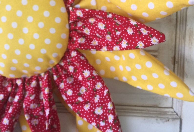 Adorable yellow and white paired with a cute red with white daisies door hanger