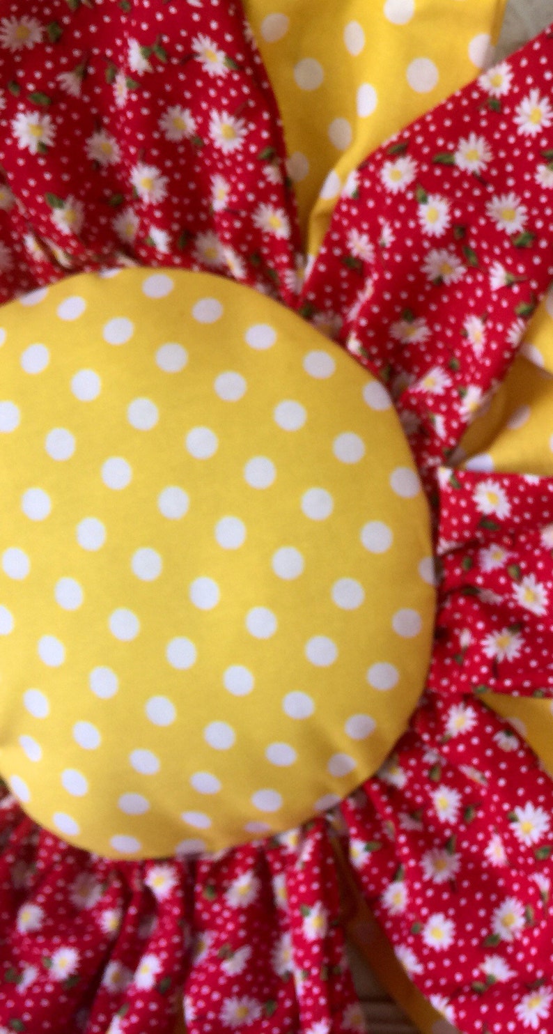 Adorable yellow and white paired with a cute red with white daisies door hanger
