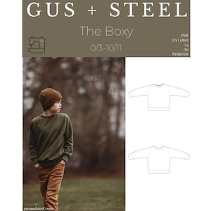 May include: An olive green sweatshirt and brown corduroy pants are worn by a child, paired with a matching beanie. The image includes a sewing pattern with the text "GUS + STEEL The Boxy 0/3-10/11". The website address "gusandsteel.com" is also visible.