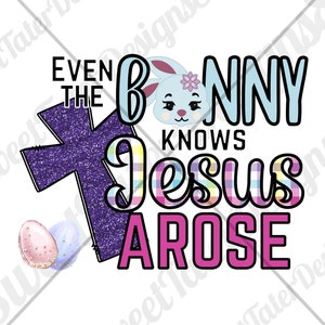 Op de afbeelding: Een paars glitterkruis met de tekst "Even the Bunny Knows Jesus Arose" in regenboogruiten en roze letters. Een cartoonkonijn met blauwe oren en een roze bloem bevindt zich in de tekst.