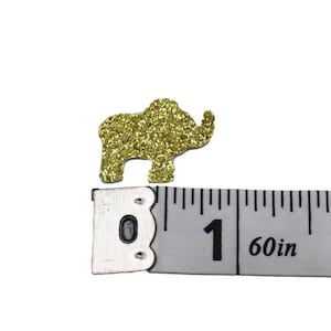 Gold glitter elephant confetti next to a ruler