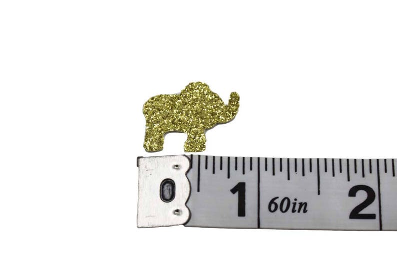 Gold glitter elephant confetti next to a ruler