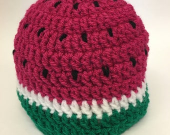 May include: A crocheted watermelon hat with a pink body, white stripe, and green bottom.