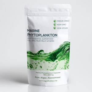 Pode incluir: Uma embalagem branca de cápsulas de fitoplâncton marinho. A embalagem apresenta o texto "Marine Phytoplankton" e "Most Essential Superfood". Também indica que o produto é liofilizado, não OGM e 100% vegano. A parte inferior da embalagem diz "Pure. Algae. Awesomess!"