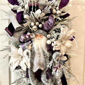May include: A purple and white Christmas swag with a Santa figurine, white poinsettias, and silver ornaments.