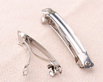 May include: Two silver hair clips, one is open and the other is closed.