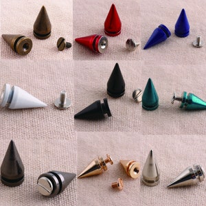 May include: Assortment of metal pyramid-shaped studs in various colours, including gold, silver, black, red, blue, and green. Each stud has a screw-on base for attaching to fabric or leather.