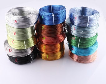 May include: A collection of 10 spools of wire in various colors, including silver, blue, green, copper, and gold. The spools are arranged in three rows, with each row containing three spools.