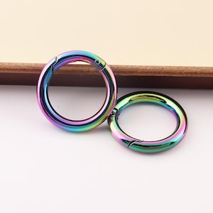 May include: Two iridescent rainbow colored metal key rings with a swivel clasp.