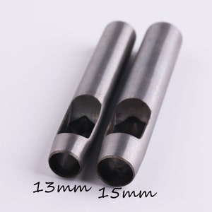 May include: Two silver metal hole punch tools with different sized holes. The larger hole punch is 15mm and the smaller hole punch is 13mm.