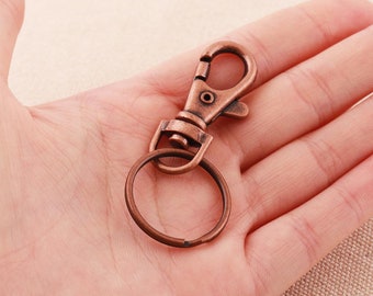 May include: A copper-toned metal key chain with a swivel clasp and a round ring.