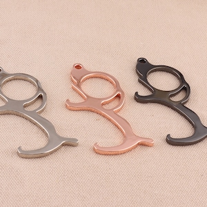 May include: Three door openers in different finishes: silver, rose gold, and black. Each opener has a loop handle and a hook on the end.