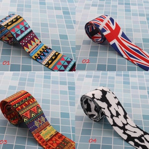 May include: Four different patterned fabric ribbon rolls. The first roll has a colorful geometric pattern with blue, red, yellow, and white. The second roll has a red, white, and blue Union Jack pattern. The third roll has a colorful geometric pattern with red, orange, yellow, and blue. The fourth roll has a black and white animal print pattern.