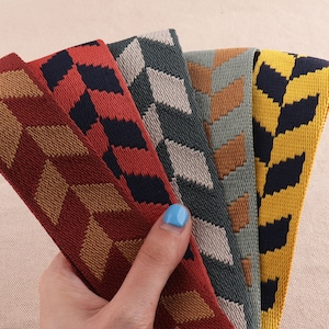 May include: Four different patterned fabric trims in red, yellow, green, and gray with black accents. The trims have a geometric chevron pattern.