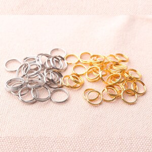 May include: A large pile of silver and gold jump rings. The jump rings are small and circular, and they are perfect for jewelry making.
