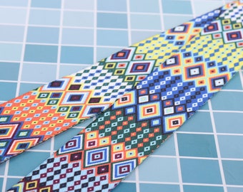 May include: Two colorful patterned fabric straps with geometric designs in shades of blue, green, yellow, orange, and white.
