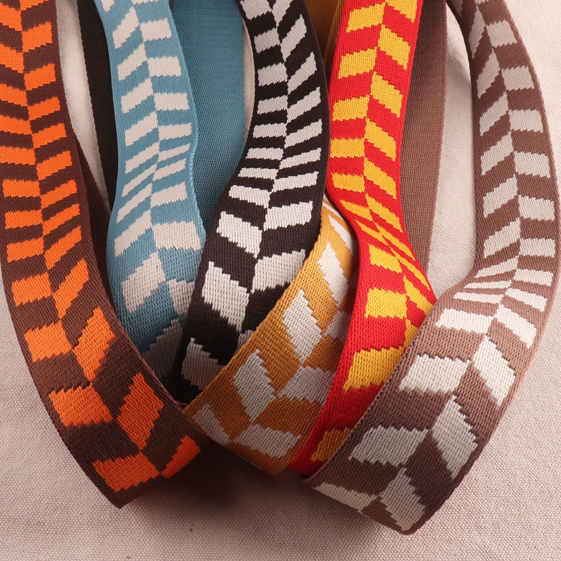 May include: Assortment of woven ribbon trim with a geometric pattern in various colors, including orange, brown, blue, yellow, and gray.
