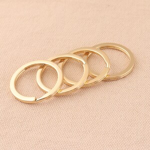 May include: Four gold-coloured metal key rings of different sizes, linked together.