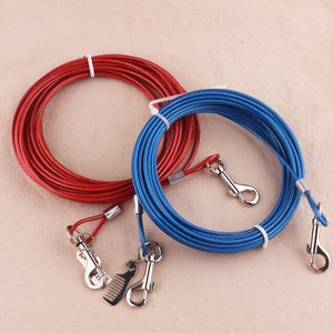 Puede incluir: Dos correas retráctiles para perros con clips metálicos. Una correa es roja y la otra es azul.