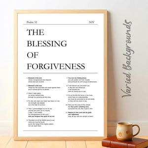 May include: A framed print with the text "THE BLESSING OF FORGIVENESS" from Psalm 32. The print is in a light wood frame and includes the NIV version of the scripture. A mug and book are in the foreground.