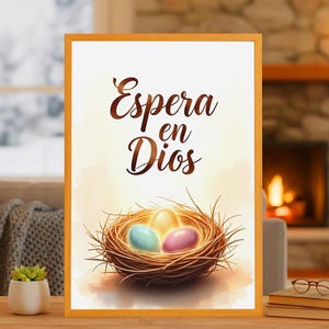 May include: A framed print featuring a nest with three colorful eggs. The text "Espera en Dios" is written in elegant script above the nest. The artwork has a warm, inviting color palette with a soft, watercolor style.